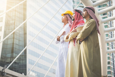 Low angle view of businessmen in thobes standing in city