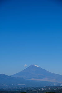 Scenic view of snowcapped mountain against blue sky