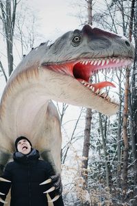 Man standing against snake sculpture