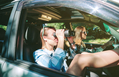 Female friends sitting in car