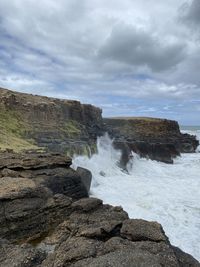 Rock formations by sea against sky