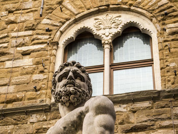 Low angle view of statue against buildings in city