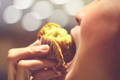 Close-up of woman eating banana cup cake