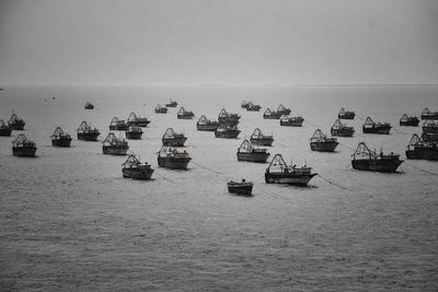 Scenic view of sea against clear sky with fishing boats anchored