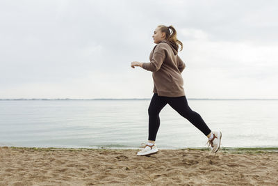 Young woman jogging on beach