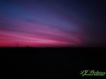 Scenic view of silhouette field against sky at sunset