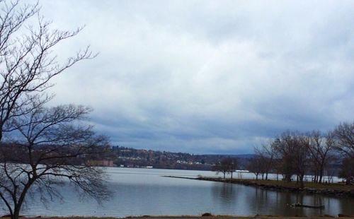 Scenic view of river against cloudy sky