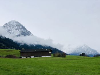 Built structure on snow covered field against sky