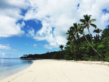 Scenic view of beach against cloudy sky