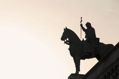 Low angle view of silhouette statue against sky