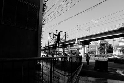 People on bridge against sky