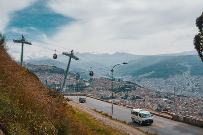 Cars on road in city against sky