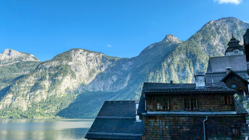 Building by mountain in hallstatt against blue sky