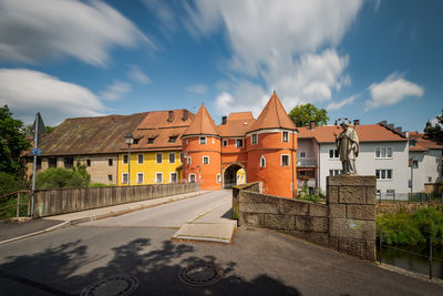 Road amidst buildings against sky