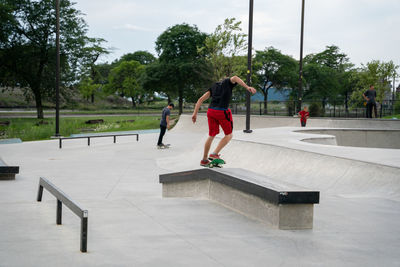People skateboarding on footpath in city