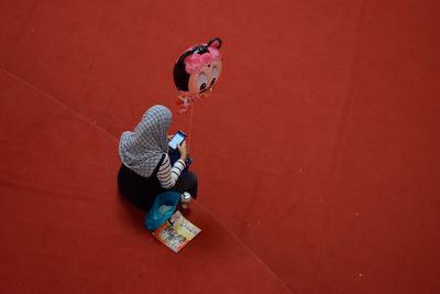 High angle view of boy sitting on wall