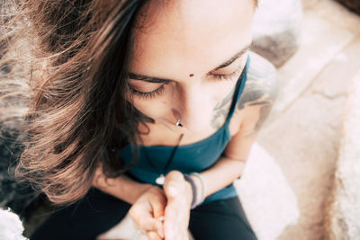 High angle portrait of young woman sitting outdoors