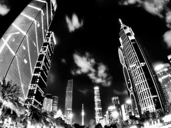 Low angle view of skyscrapers against cloudy sky