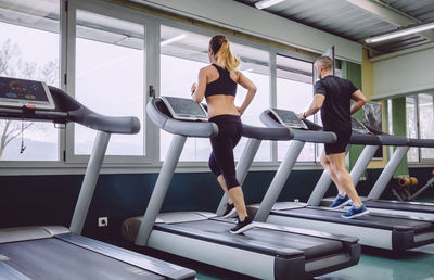 People running on treadmills in gym