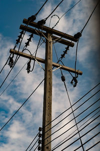 Low angle view of electricity pylon against sky