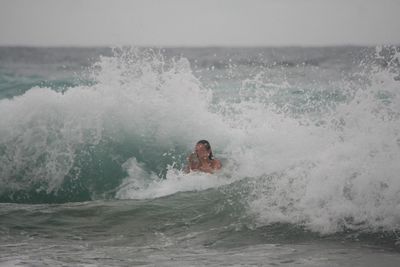 Young man splashing water in sea