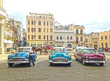 People on road against buildings in city