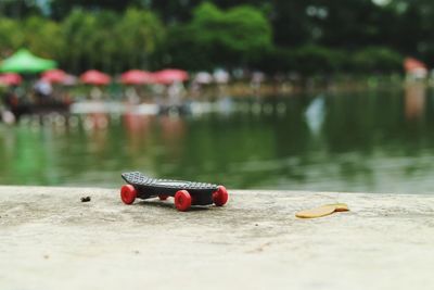 Skateboard on pier over lake at park