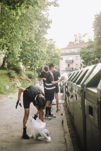 Volunteers putting plastic garbage in recycling bin