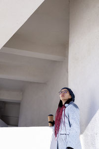Young asian girl eco-friendly . reusable glass for hot drink. walk on the street.