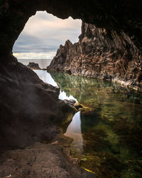 Rock formations by sea against sky