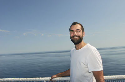Portrait of smiling man in sea against sky