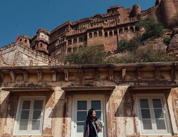 Woman standing against historical buildings