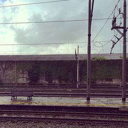 Railroad tracks against cloudy sky