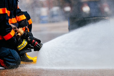 Low section of firefighter spraying water