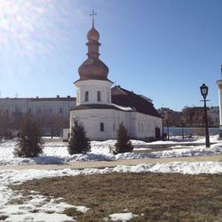 Church by building against clear sky during winter