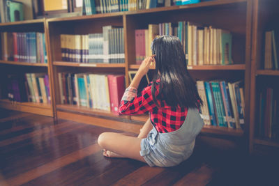 Girl using digital tablet while sitting in library