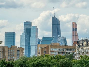 Buildings in city against cloudy sky