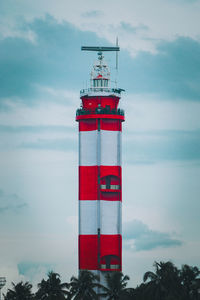 Lighthouse by sea against sky