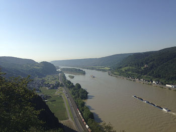 Scenic view of river and mountains against clear blue sky