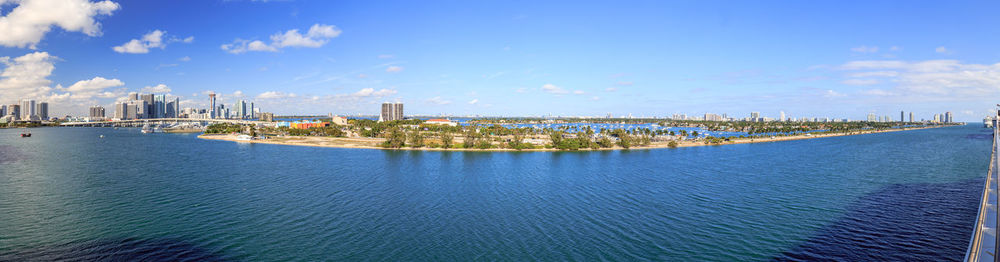 Panoramic view of city by sea against sky