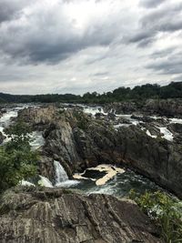 Scenic view of river against cloudy sky