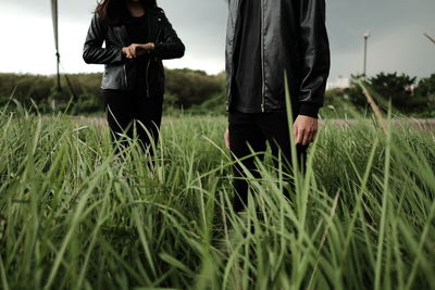 Midsection of couple standing on grass