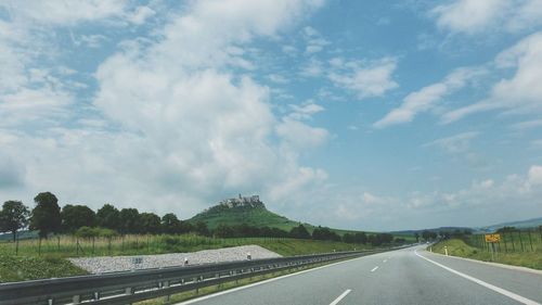 Road amidst trees against sky