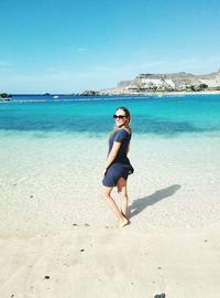 Full length portrait of young woman standing on beach