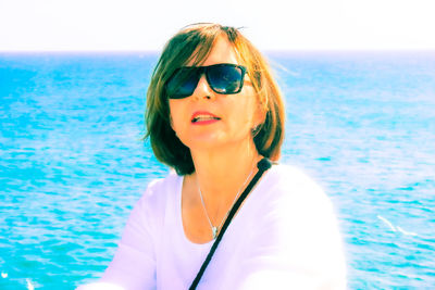 Portrait of woman wearing sunglasses at sea