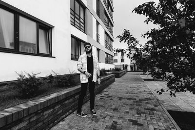 Young man smoking while standing against building