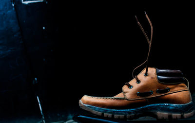 Close-up of shoes on table against black background