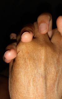 Close-up of human hand against black background