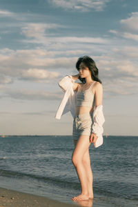 Side view of woman standing at beach