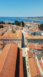 High angle view of townscape by sea against clear sky